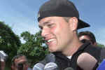 New England Patriots quarterback Tom Brady answers questions from the media before a team meeting as the Patriots begin their first day of full training camp at Bryant College in Smithfield, R.I., Friday, July 26, 2002. (AP Photo/Stew Milne) 