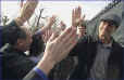 New England Patriots quarterbacks Tom Brady, right, and Drew Bledsoe, backround right, take high fives from the fans gathered outside the Statehouse. (BostonHerald)